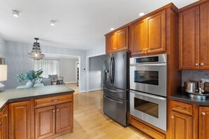 This fully equipped kitchen, which includes a fridge, two built-in wall ovens, a dishwasher, and a gas stove, will thrill food connoisseurs.