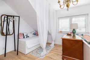 Another view of the living area featuring a standing coat rack and vintage-style furniture.

