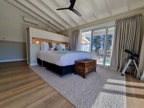 The primary bedroom features sweeping glass doors that look out to the outdoor area and paddock plains. At night enjoy the sunsets and stargazing through the telescope. 