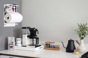 Moccamaster, Metric coffee grounds, sugar, creamer, electric kettle, spices, paper towels. 