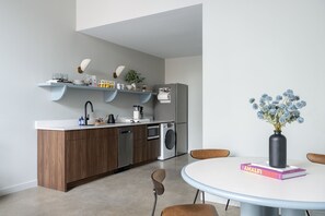 Sink, dishwasher, washer/dryer, refrigerator, plates, bowls, cutlery, cooking ware, spices, cleaning supplies, steamer, portable vacuum, moccamaster, Metric coffee grounds, electric kettle, bottled water. 