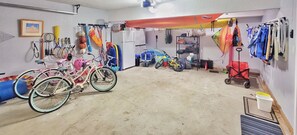 Garage stocked with beach chairs, carts, bikes, a propane grill, kayaks and more