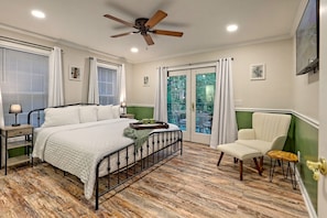 Unwind in the serene master bedroom at Helen Waldhaus, featuring a plush king bed, stylish decor, and French doors leading to a private outdoor retreat.