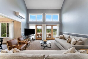 Bright, airy living room with floor-to-ceiling windows, offering breathtaking mountain views