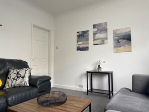 Relax in style in our inviting living room. Enjoy entertainment on a large smart TV, and take in the cozy ambiance. With ample seating, tasteful decor, and a welcoming atmosphere, it's the perfect space to unwind and create lasting memories.