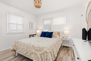 Primary bedroom with a queen bed, Smart TV, and private bathroom