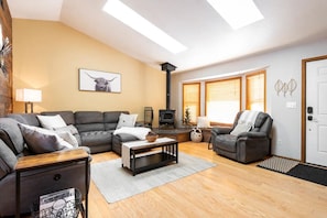 Cozy living room with a comfy sofa, lounge chair, with natural light pouring in from the skylights.