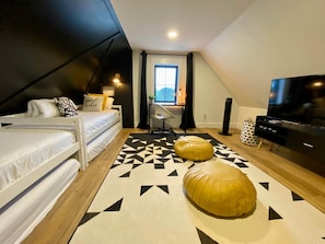 The loft features a smart TV, retro gaming console, work station and 4 twin beds.