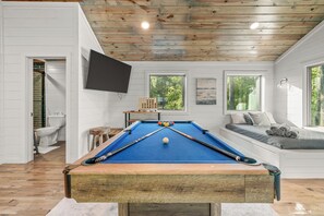 Discover the Upstairs Loft Bedroom, with two queen beds, along with a pool table, game console, and trunk full of additional games, along with a 50” smart TV.