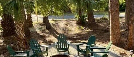 Large fire pit area where everyone loves to gather with 8 Adirondack chairs.