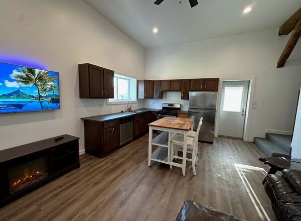 {LIVING ROOM} 55" Smart TV and electric fireplace and kitchen.