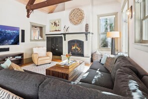 Welcome into the living room with vaulted ceiling, fireplace & cozy sectional