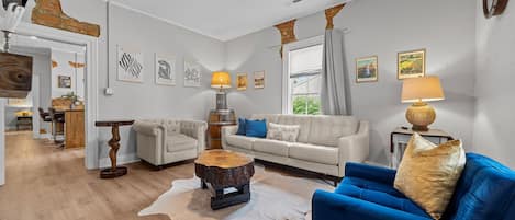 Living room with custom made live edge tables, leather couch & cozy chairs