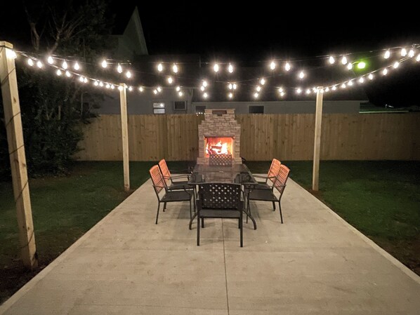 Stone fireplace on the patio featuring a pizza oven & a large dining space