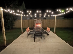 Stone fireplace on the patio featuring a pizza oven & a large dining space