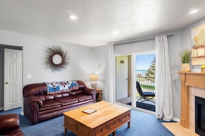 Living area and balcony - gas fireplace, two sofa sleepers, coffee table.