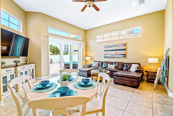 Bright and full of charm, this cozy living space invites you to gather around the table or kick back on the comfy leather sofa.