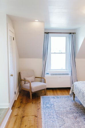 Relax in Sarah's Room with a plush armchair, soft lighting, and charming window views. A perfect corner to unwind during your Boothbay Harbor stay at the historic Greenleaf Inn.