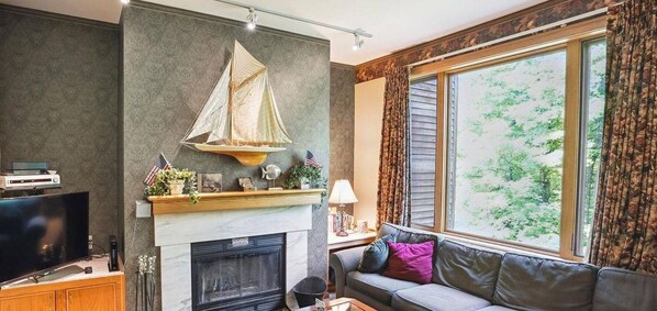Tastefully decorated living room. Enjoy the warm glow from the wood burning fireplace.