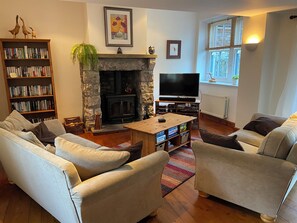 Spacious living room with welcoming log fire and DVDs, books and games