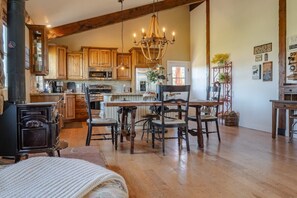 Imagine dining in this exquisite space! The open-concept design, rustic wooden furniture, and elegant chandelier create a perfect setting for memorable meals. You'll appreciate the seamless blend of comfort and style in this charming retreat. (Cowboy House)