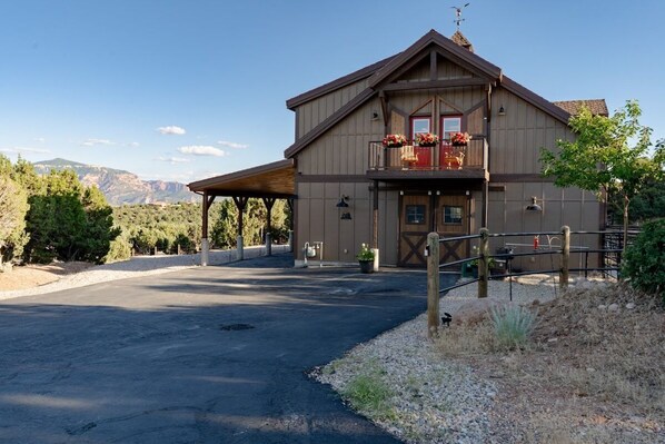 Welcome to your serene retreat! Nestled among lush greenery, this charming cabin offers breathtaking mountain views and ultimate tranquility. You'll adore the cozy balcony with vibrant flowers, perfect for your morning coffee or evening relaxation.(Barn loft exterior)
