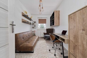 The stylish bedroom includes a comfortable sofa bed and a desk.