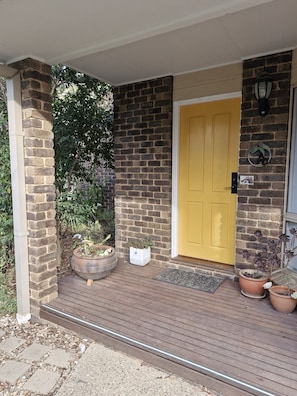 Lockbox is located on the pillar to the left of the yellow front door.