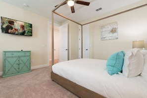 Experience stylish comfort in this modern bedroom, complete with a chic four-poster bed and a state-of-the-art television for your entertainment. The room's soft pastel accents and elegant decor create a welcoming atmosphere