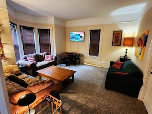 Pull out sofa, chess set, BT DJ speaker, mini-fridge, and 42" smart TV.