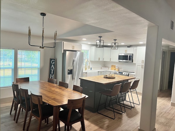 Open concept kitchen and dining table with a eight chairs.