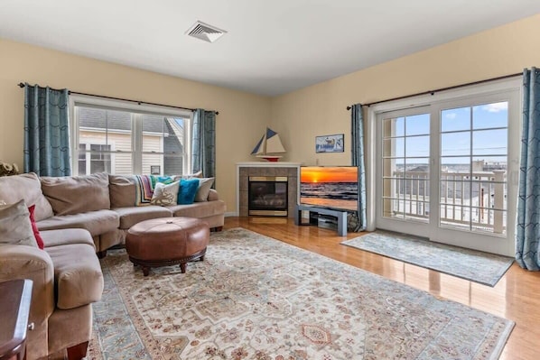 Open living room with gas fireplace and slider onto your private deck. Cozy up and relax.