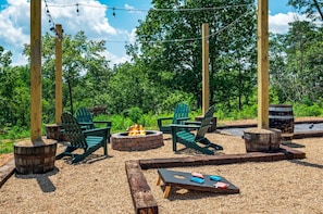 Outdoor area with firepit, cornhole and bocce ball.