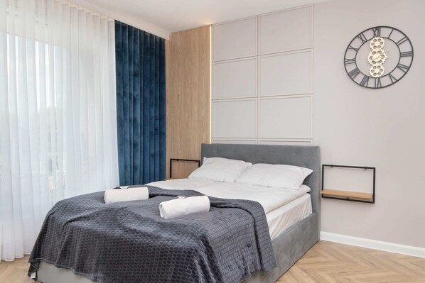 The living area features a sleek dining space and a flat-screen television.