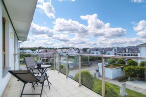 A spacious balcony with outdoor seating and beautiful views of the surrounding neighborhood, ideal for relaxing or enjoying coffee.