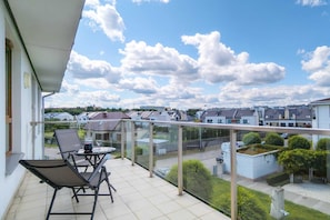 A spacious balcony with outdoor seating and beautiful views of the surrounding neighborhood, ideal for relaxing or enjoying coffee.