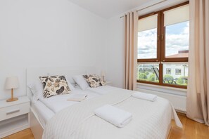 A cozy bedroom featuring a comfortable double bed, elegant bedding, and bedside lamps for a relaxing atmosphere.