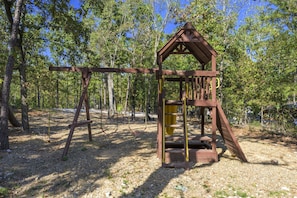 Playground Paradise: Fun-filled days await on this wooden playscape nestled in nature!