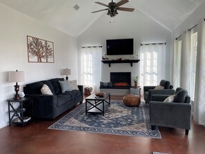 Living room with a 55” Roku TV and electric fireplace. 