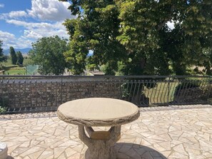 Gîte 'La Terrasse' à Mornant (Rhône, Ouest Lyonnais) : table en pierre sur la terrasse.