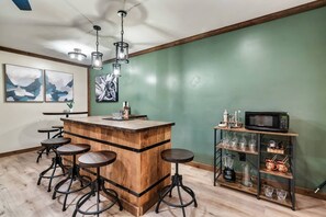 Custom Bar and Kitchenette, complete with a sink, a microwave, and a mini fridge.