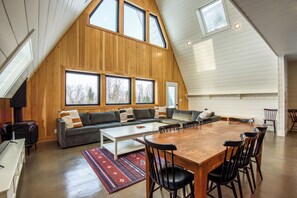 Cozy living space with a panoramic mountain view framed by large picture windows - a perfect spot to relax and unwind after a long day on the slopes