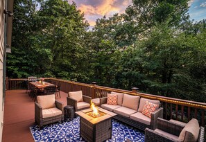 Upper deck features couches with propane firepit, dining for 10, and gas grill