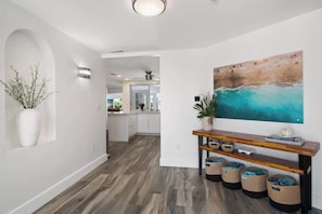 The welcoming entryway leads to the main living area of the home, which features an open floor plan with a comfortable living room, dining area, and modern kitchen