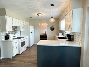beautiful fully stocked kitchen, gas stove, and dishwasher.