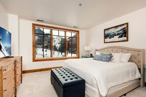 - Spacious bedroom with plush comfortable king bed, tufted headboard, and calming décor
- Large window frames snowy mountain views and lets in natural light
- Watch the skiers glide by or unwind with your favorite show on the flat screen