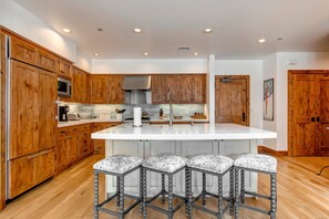 - Spacious gourmet kitchen with custom wood cabinetry and modern appliances
- Large quartz island with stylish barstools, ideal for casual dining or prep
- Warm mountain charm meets functionality in this fully equipped culinary space