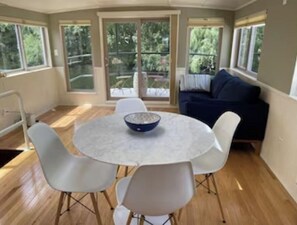 Open dining area with city skyline views from table and couch