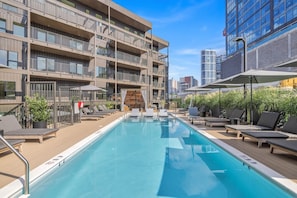 Communal Area: Sparkling blue pool with covered cabanas, sun loungers, and a wheelchair lift.