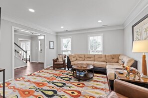 Primary living room with plush, ample seating and flat screen Roku TV.